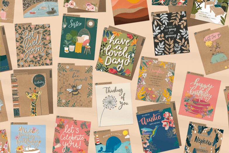 A range of greetings cards, laid flat on a light coloured backgroud.